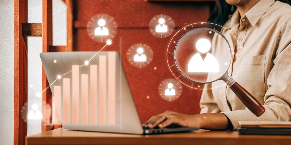 mprendedor usando una lupa para analizar un Buyer Persona, con iconos de datos flotando, simbolizando la investigación de cliente ideal.